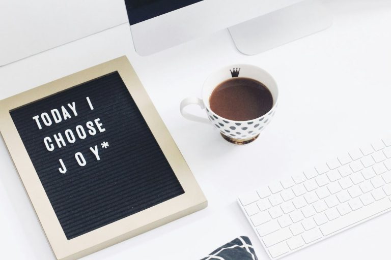 Telrfonnummer Schwarzes Board mit der Aufschrift „Today I choose joy“ und einer Tasse Kaffee.